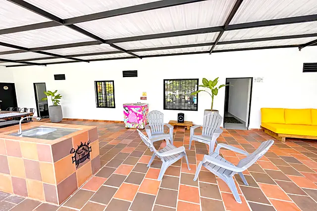 Zona social de la terraza con sillas, sofá y barra de BBQ